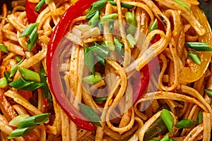 Vegetarian Schezwan Noodles or Vegetable Hakka Noodles or Chow Mein in black bowl at dark background. Schezwan Noodles is indo-