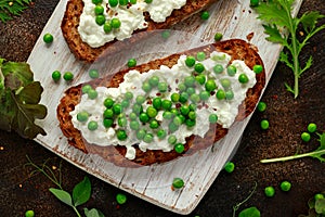 Vegetarian seeded sourdough bread open sandwich with cottage cheese and petit poit peas sprinkled with chilli flakes
