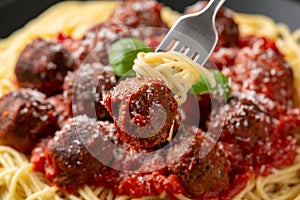 Vegetarian spaghetti with meat free, vegan meatballs in rich tomato sauce, grated cheese and basil leaves