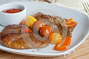 Vegetarian steak made from vegan meat seitan, with cherry tomatoes