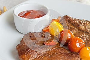 Vegetarian steak made from vegan meat seitan, with cherry tomatoes