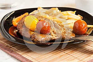 Vegetarian steak from vegan meat seitan, cherry tomatoes and fries