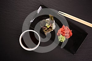 Vegetarian sushi roll over black stone table