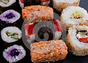 Vegetarian sushi set on a black board  with chopsticks on black background