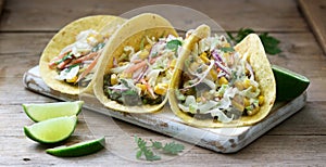 Vegetarian tacos stuffed with cabbage salad on a wooden background. Rustic style