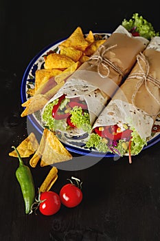 Vegetarian tartilla home with tomatoes, cabbage, cheese and salad. Mexican food. Nachos chips.