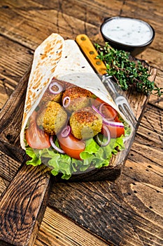 Vegetarian Tortilla wrap with falafel and fresh salad, vegan tacos. wooden background. Top view