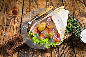 Vegetarian Tortilla wrap with falafel and fresh salad, vegan tacos. wooden background. Top view