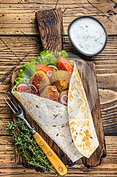 Vegetarian Tortilla wrap with falafel and fresh salad, vegan tacos. wooden background. Top view