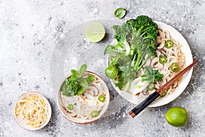 Vegetarian traditional Vietnamese soup Pho bo with herbs, rice noodles, broccolini, bok choy. Asian food concept. photo