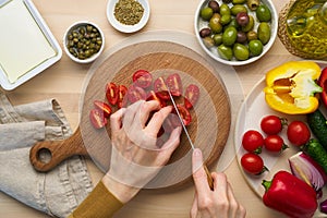 Vegetarian vegan food. Chopping tomatoes, cutting vegetables for greek salad horiatiki.