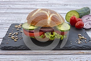 Vegetarian or vegan round sandwich with tomato, lettuce, onion and cucumber. Eat healthy and feel good