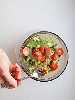 Vegetarian vegetable salad. Fresh salad flying to bowl in super slow motion. Avocado Tomato Salad