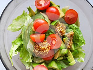 Vegetarian vegetable salad. Fresh salad flying to bowl in super slow motion. Avocado Tomato Salad