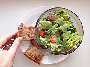 Vegetarian vegetable salad. Fresh salad flying to bowl in super slow motion. Avocado Tomato Salad