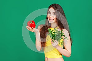 Vegetarian Young woman holding fresh raw vegetables salad pepper cucumber and parsley on green background. Healthy food Lifestyle