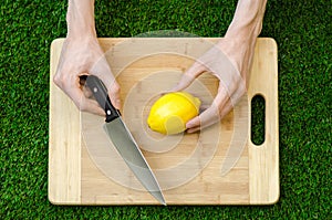 Vegetarians and cooking on the nature of the theme: lying on a cutting board and knife lemon yellow on the background of grass