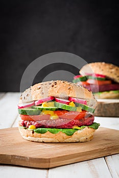 Veggie beet burger on a white wooden table and black background