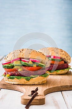 Veggie beet burger on white wooden table and blue background