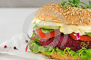 Veggie burger with beet and avocado on white marble table. Healthy vegan food