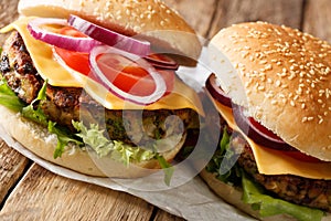 Veggie burger with fresh lettuce, onions, tomatoes and cheddar cheese close-up. horizontal