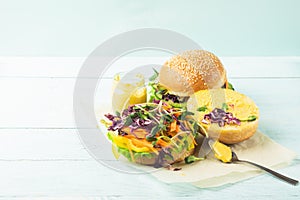 Veggie burger with fresh raw vegetables close up on a blue background. Healthy eating concept. Selective focus