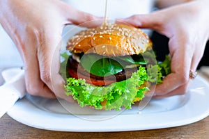 Veggie burger healthy vegan food. Salad, avocado, vegetable on vegetarian hamburger eating cute woman. Vegan sandwich