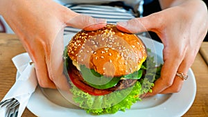 Veggie burger healthy vegan food. Salad, avocado, vegetable on vegetarian hamburger eating cute woman. Vegan sandwich