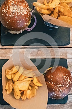 Veggie burgers in a bun with sesame seeds . Delicious fast food for vegans on a wooden background.