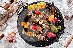 Veggie kebabs grilling on a winter BBQ