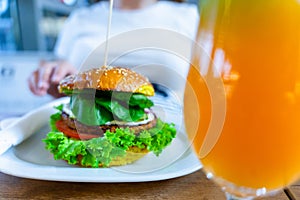 Veggie sandwich healthy vegan burger. Cute cheerful girl eating vegetarian hamburger with salad, avocado, vegetable