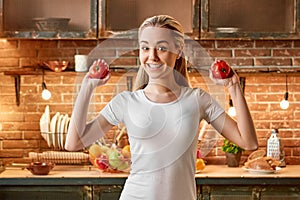 Veggies don t cause wedges. Happy young woman cutting fresh vegetables in modern kitchen. Cozy interior