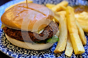 Veggy burger served with fried potato and hot chuthey sauce