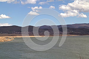 Vegoritida lake under cloudy sky with cliffs in the background