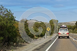 Vehicle with camping equipments on top driving on Cape du Couedic road on Kangaroo Island, South Australia