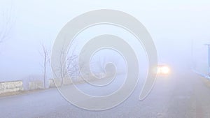 Vehicle coming out of a thick fog with switch on headlights