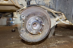 Vehicle disc brake for repair, in the process of replacing new tires. Repair of car brakes in the garage.