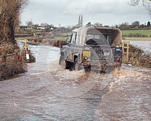Vehicle Driving Through Flood Water On Road