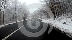 Vehicle driving trough scenic mountian road in winter