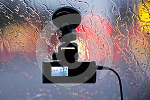 Vehicle DVR on glass of car in rain lights reflection