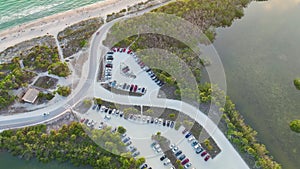 Vehicle parking area with cars parked on ocean beach parking lot. Summer vacation on beachfront in Southern Florida