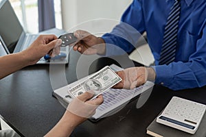 Vehicle rental business concept Close up of hands of car rental agent giving car remote key