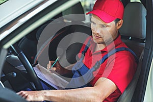 Vehicle technical inspection - man sitting inside the car and checking dashboard photo