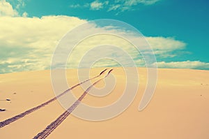 Vehicle tracks over a remote, deserted sand dune