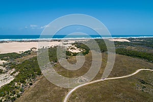 Vehicle on unsealed road near the ocean.