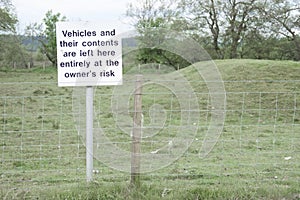 Vehicles and contents left at owners risk sign post responsibility theft loss damage at remote rural countryside national park