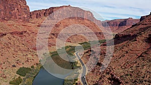 Vehicles Drive On Asphalt Highway Along Colorado River In Red Rock Canyon Gorge