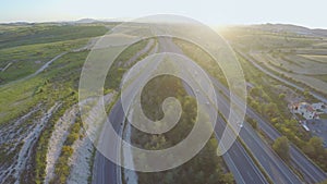 Vehicles moving on interstate highway. Beautiful sunset on horizon. Aerial shot