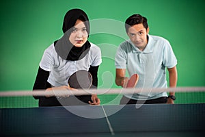 Veiled female and male ping pong players ready to play