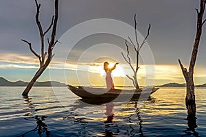 Veiled Islamic muslim woman wearing a burka standing and praying on the boat